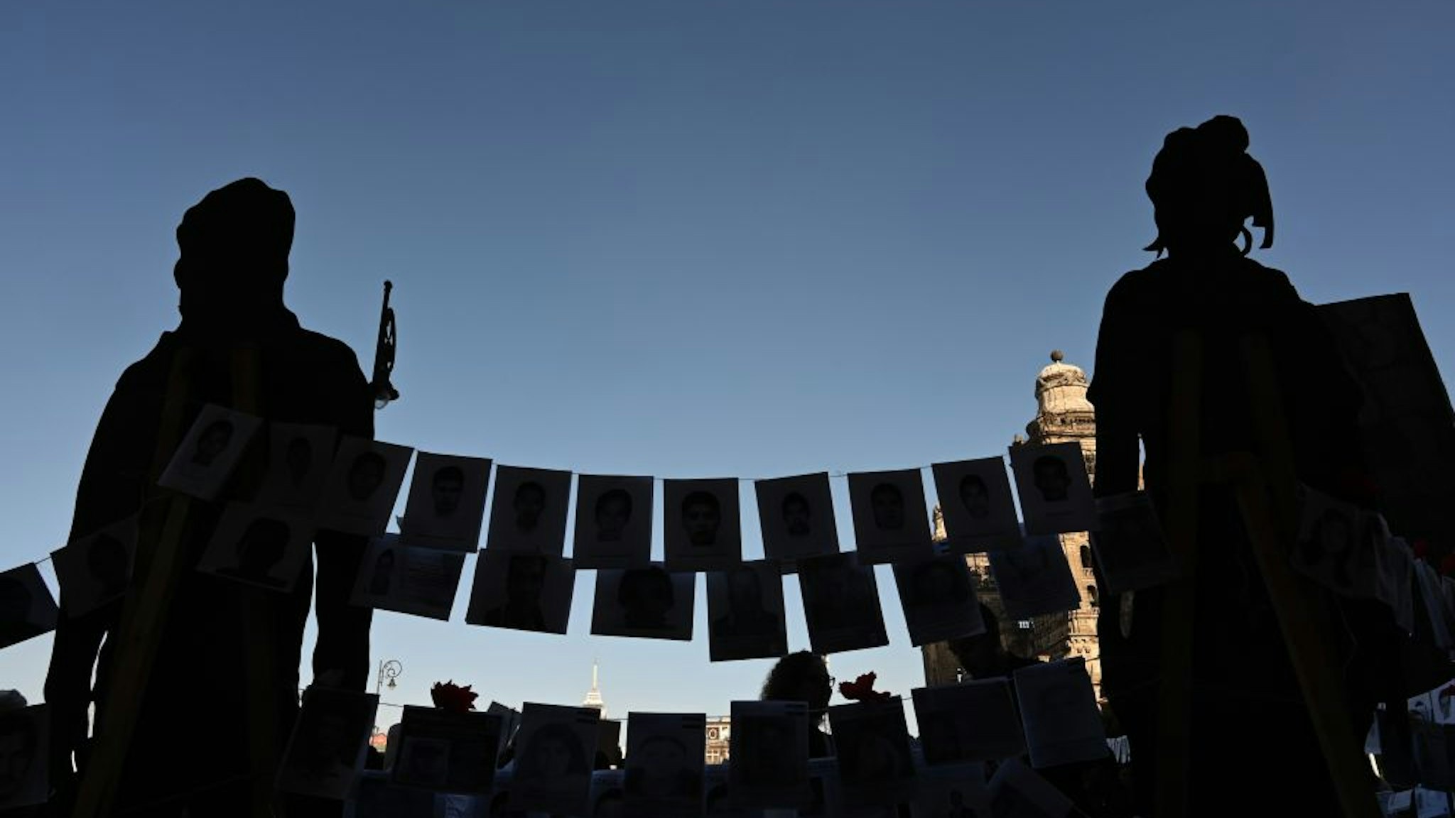 Pictures of missing persons hang from a rope in front of the National Palace during the commemoration of the International Day of the Disappeared in Mexico City, on August 30, 2019. - More than 40,000 people are missing in Mexico, which has been swept by a wave of violence since the government declared war on the country's powerful drug cartels in 2006. (Photo by RODRIGO ARANGUA / AFP) (Photo credit should read RODRIGO ARANGUA/AFP via Getty Images)