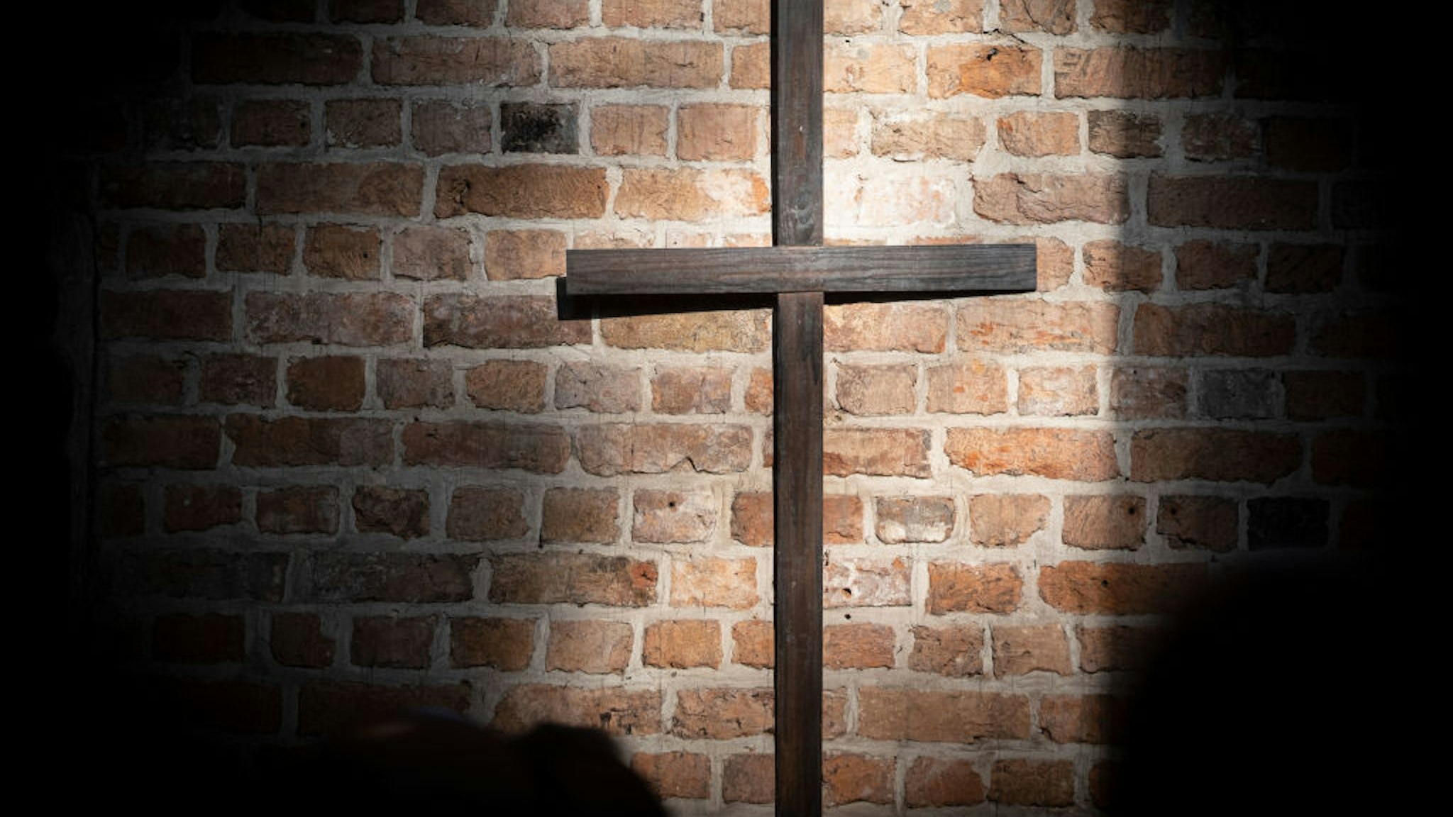 An old wooden cross can be seen in a sunspot on the wall of the market church during the church service on Reformation Day. Reformation Day is the third holiday in Lower Saxony. Photo: Peter Steffen/dpa (Photo by Peter Steffen/picture alliance via Getty Images)