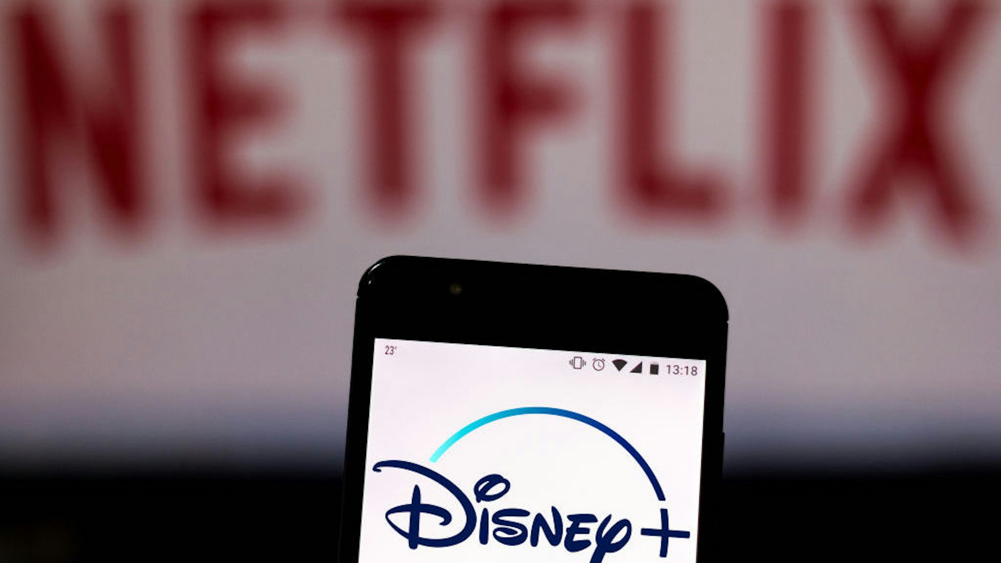 In this photo illustration the Disney Plus logo is seen displayed on a smartphone and logo Netflix on the blurred background. (Photo Illustration by Rafael Henrique/SOPA Images/LightRocket via Getty Images)