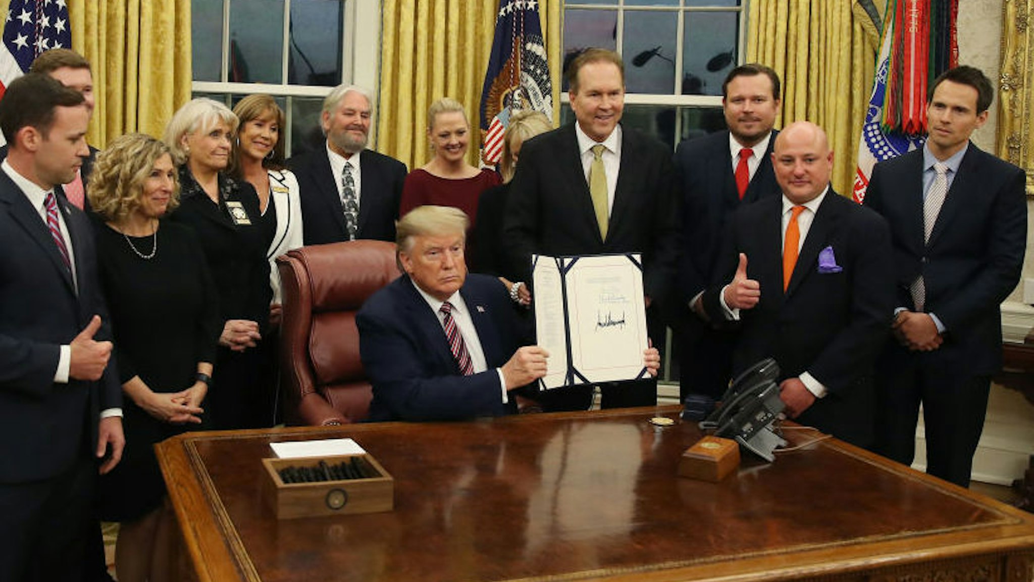U.S. President Donald Trump poses with animal rights supporters after signing H.R. 724, the Preventing Animal Cruelty and Torture Act, in the Oval Office at the White House on November 25, 2019 in Washington, DC. (Photo by Mark Wilson/Getty Images)