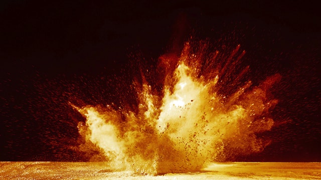 Explosion by an impact of a cloud of particles of powder and smoke of color yellow and orange on a black background.
