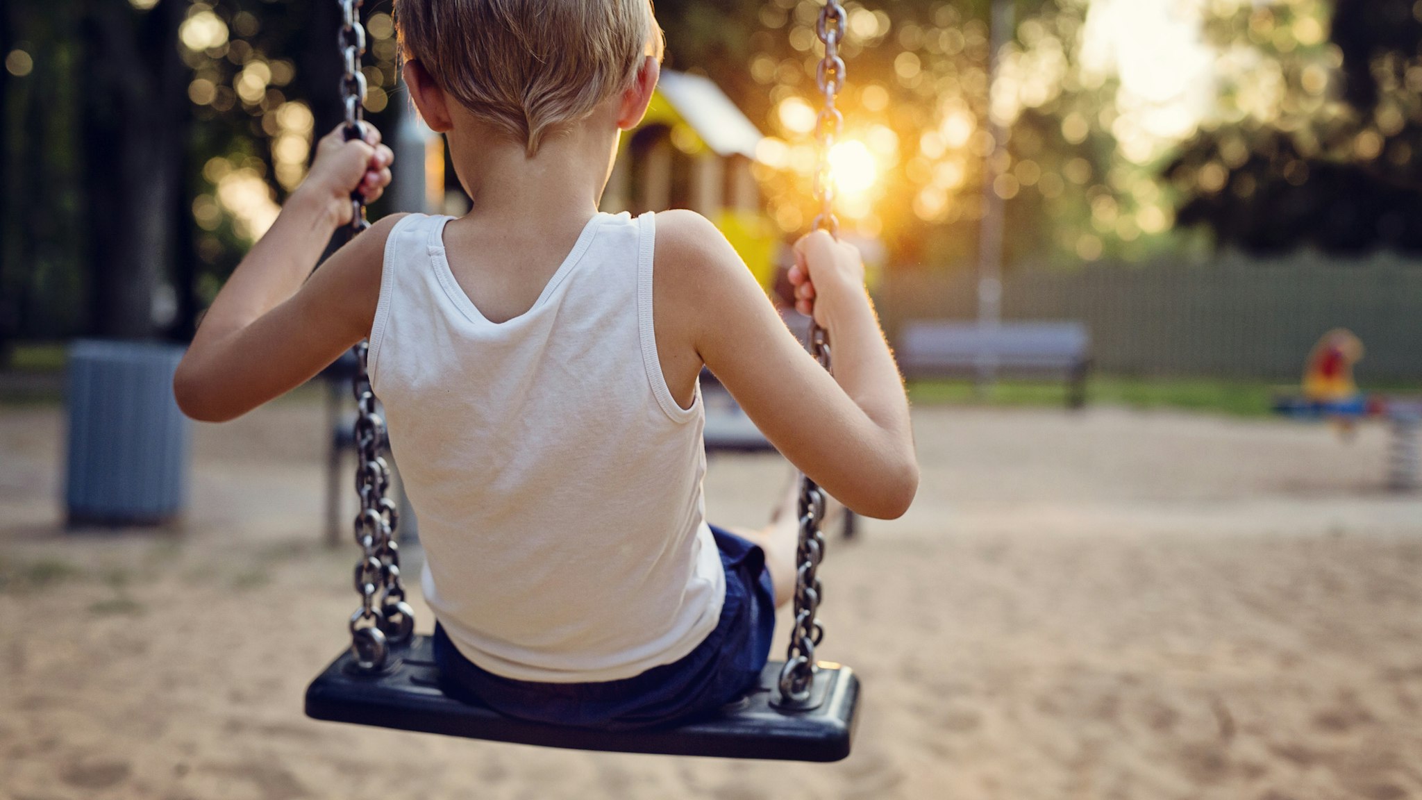 Young boy on swing - stock photo