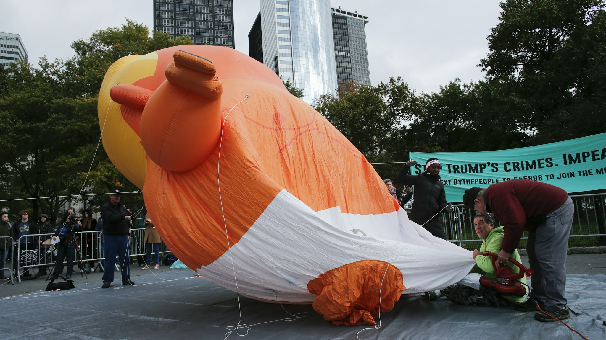 The Baby Trump Balloon is unfurled as it makes an appearance in New York as part of an "Impeachment Parade" protest on October 28, 2018 in New York City. The 20-foot balloon that flew over London, Chicago and Los Angeles earlier this year made its New York debut during a protest organized by "By the People," a grassroots campaign calling for the impeachment of President Trump. (Photo by Kena Betancur/Getty Images)