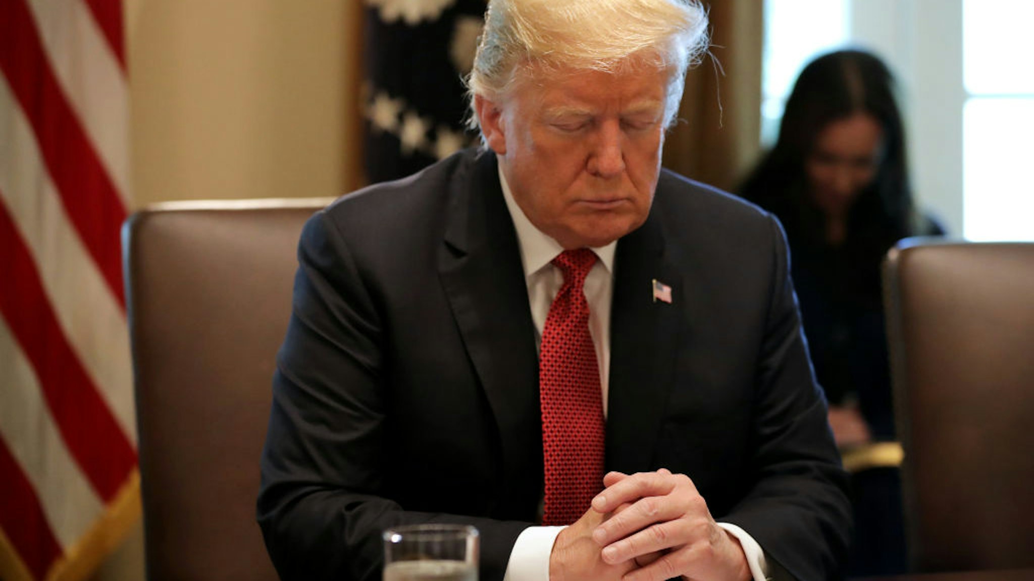 U.S. President Donald Trump closes his eyes during a prayer before a meeting of his cabinet in the Cabinet Room at the White House October 17, 2018 in Washington, DC.