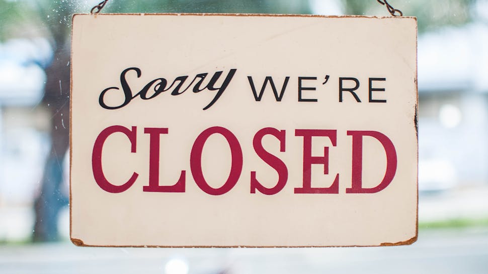 Store closed sign hanging on the window Sorry we're closed