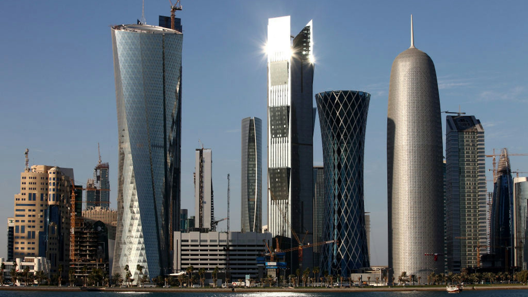 DOHA, QATAR - DECEMBER 30: New high-rise office buildings and hotels, some of them still under construction, stand in the West Bay and Oneiza district near City Center mall and build the skyline at the opposite of the promenade at the Al Corniche road on December 30, 2010 in Doha, Qatar. The International Monetary Fund (IMF) recently reiterated its projection for the Qatari economy with predictions of double digit growth for 2010 and 2011. Though natural gas and petroleum production are still the biggest two single sources of income, the non-energy sector overtook oil and gas in Qatari GDP for 2009. The FIFA world cup 2022 will takes place in Qatar.