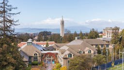 UC-Berkeley campus BERKELEY, CA - DECEMBER 1: A general view of the University of California Berkeley campus including Sather Tower, also known as The Campanile, as seen from Memorial Stadium before the 121st Big Game played between the California Golden Bears and the Stanford Cardinal football teams on December 1, 2018 at the University of California in Berkeley, California. The Haas School of Business is visible in foreground (with gabled roofs), San Francisco Bay in the background.