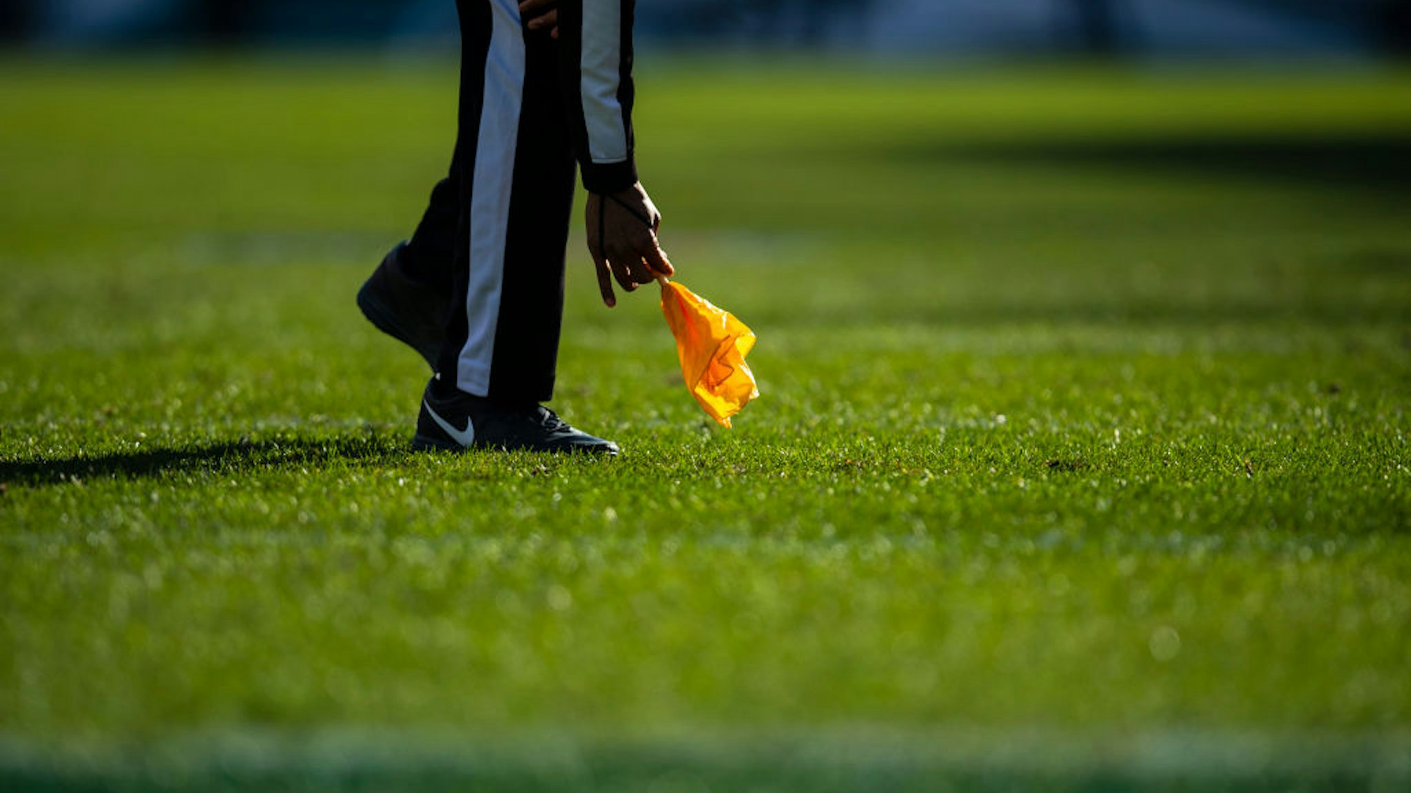 A referee picks up a yellow penalty flag during the game between the Philadelphia Eagles and the Houston Texans at Lincoln Financial Field on December 23, 2018 in Philadelphia, Pennsylvania. Photo by Brett Carlsen/Getty Images