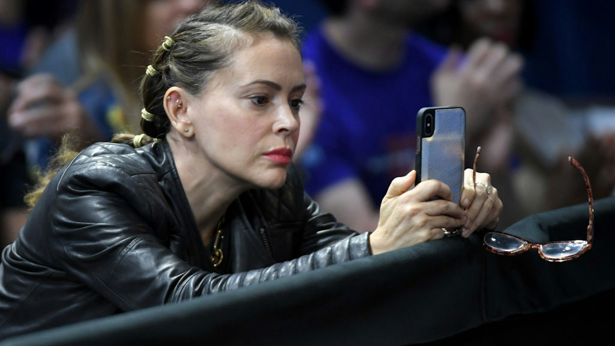 Actress Alyssa Milano records Democratic presidential candidate, entrepreneur Andrew Yang (not pictured) as he speaks during the 2020 Gun Safety Forum hosted by gun control activist groups Giffords and March for Our Lives at Enclave on October 2, 2019 in Las Vegas, Nevada.