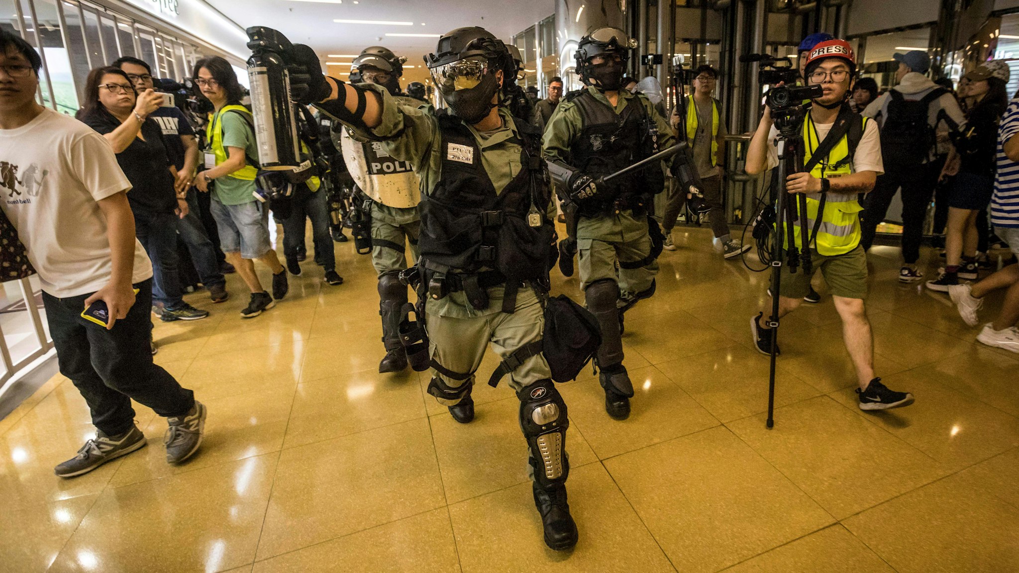 A riot police officer chases a protester while wielding a can of pepper spray inside the City Plaza mall in the Tai Koo Shing area in Hong Kong on November 3, 2019, after a bloody knife fight wounding six people triggered there. - A bloody knife fight in Hong Kong left six people wounded on November 3 evening, including a local pro-democracy politician who had his ear bitten off, capping another chaotic day of political unrest in the city. (Photo by VIVEK PRAKASH / AFP) (Photo by VIVEK PRAKASH/AFP via Getty Images)