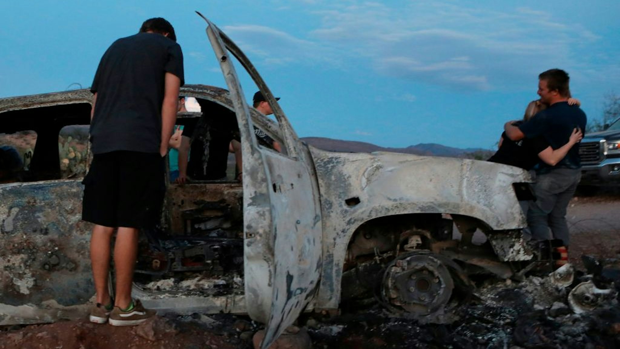 Members of the Lebaron family look at the burned car where part of the nine murdered members of the family were killed and burned during an ambush in Bavispe, Sonora mountains, Mexico, on November 5, 2019.