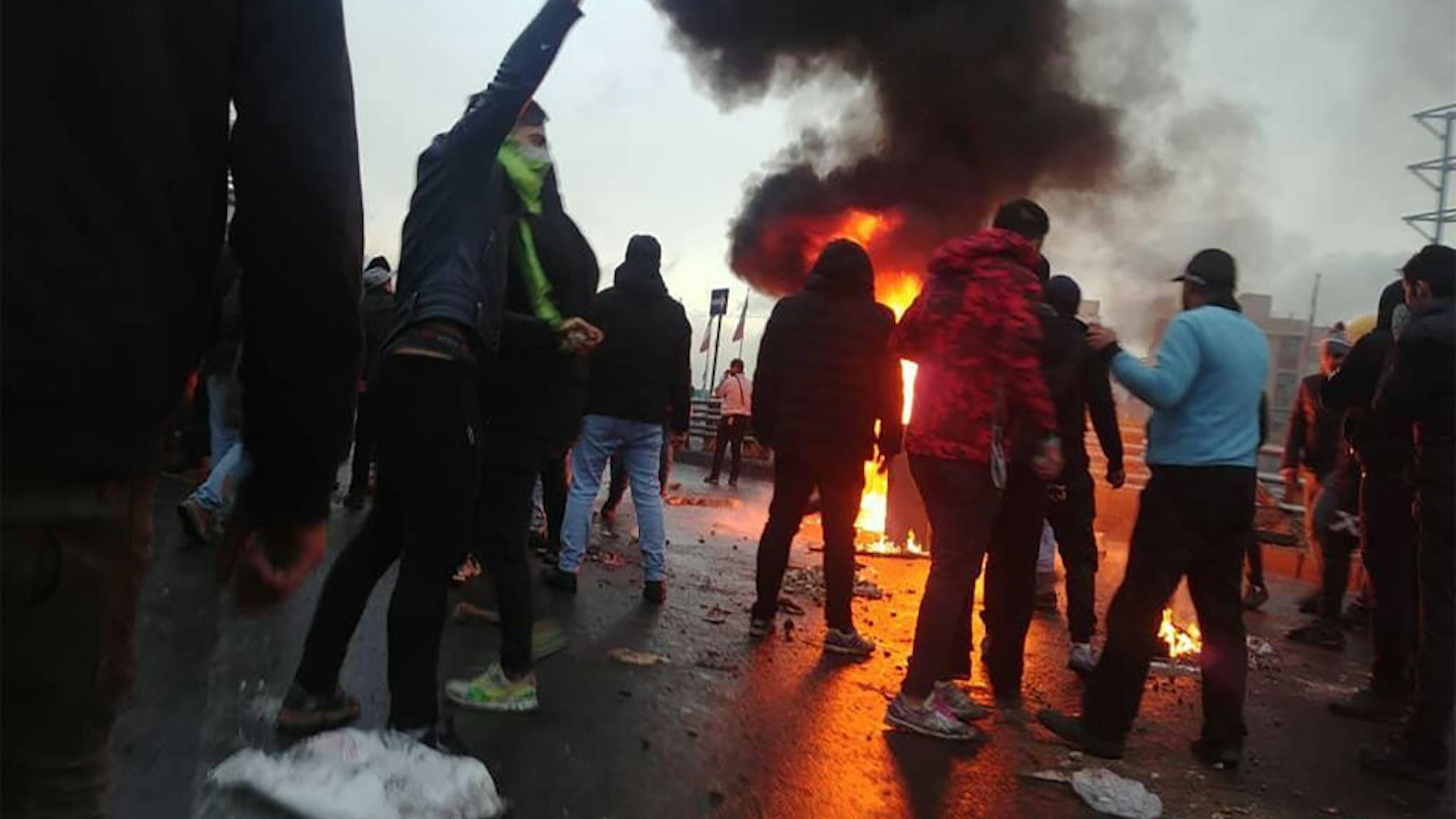 Iranian protesters gather around a fire during a demonstration against an increase in gasoline prices in the capital Tehran, on November 16, 2019.