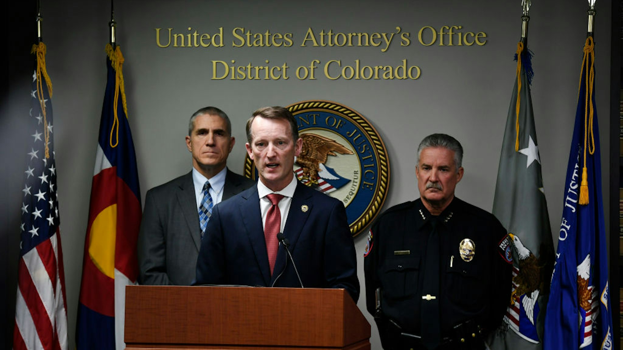 U.S. Attorney Jason R. Dunn, center, speaks during a press conference at U.S. Attorney's Office on November 4, 2019 in Denver, Colorado. The FBI announced that they arrested Richard Holzer on domestic terrorism charges for his plot to blow up Temple Emanuel Synagogue in Pueblo. The 27-year-old Pueblo man, who hoped to incite a racial holy war and plotted ways he could destroy the second-oldest synagogue in Colorado to “get that place off the map,” is accused of domestic terrorism and a hate crime by federal authorities. With Dunn at the podium are Dean Phillips, FBI Denver Division Special Agent in Charge, left, and Troy Davenport, right, Pueblo Police Chief.