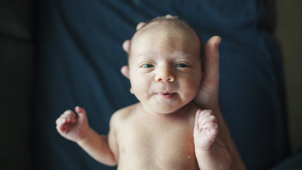 Cavan Images//Getty Images Overhead portrait of newborn baby boy held by father in hospital - stock photo