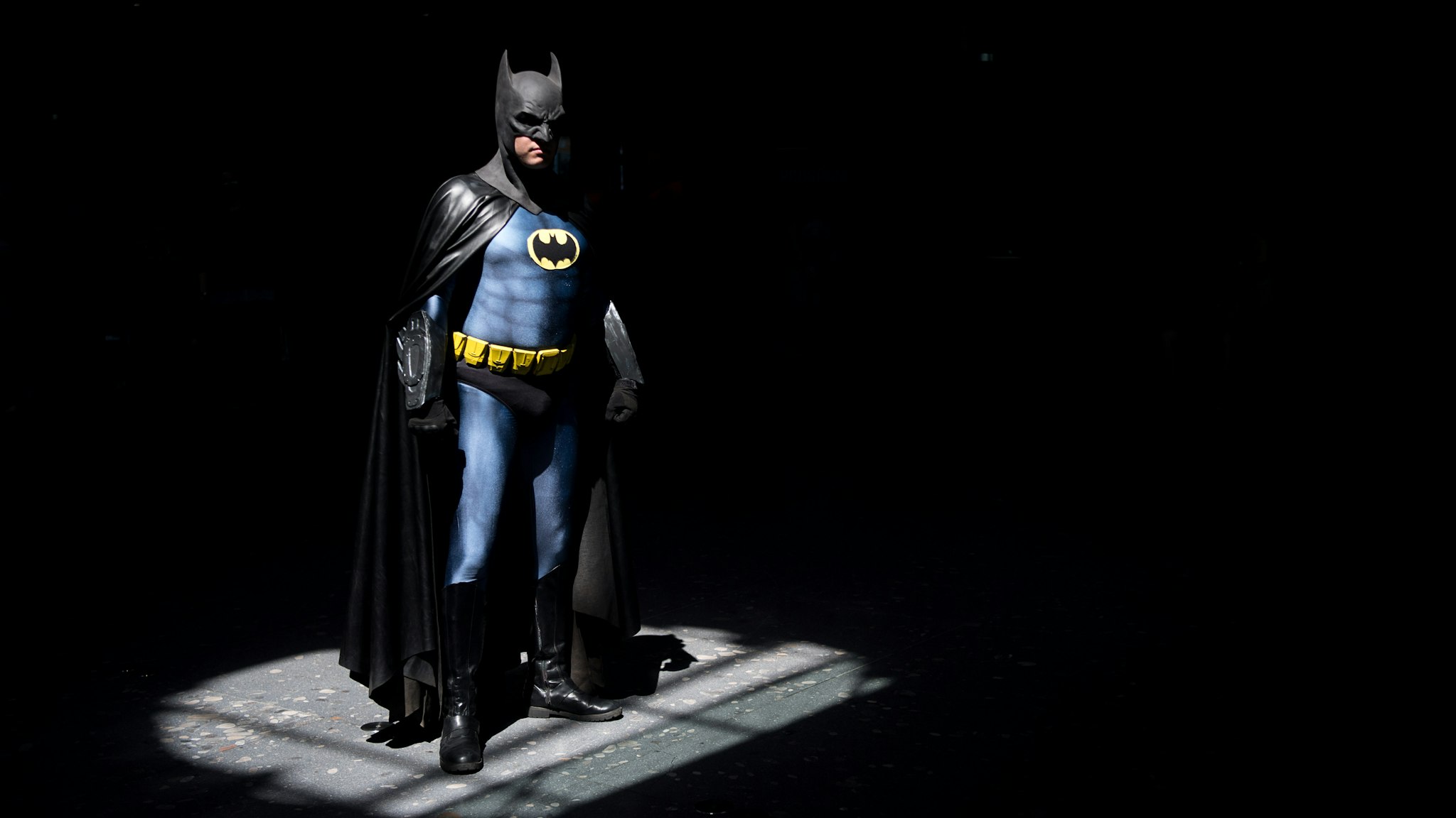 30 June 2018, Germany, Stuttgart: A cosplayer wearing a batman outfit standing in the spotlight during the first day of the pop culture fair "Comic Con Germany" at the Stuttgart trade fair. The fair is taking place from 30 June to 01 July. Photo: Sebastian Gollnow/dpa (Photo by Sebastian Gollnow/picture alliance via Getty Images)