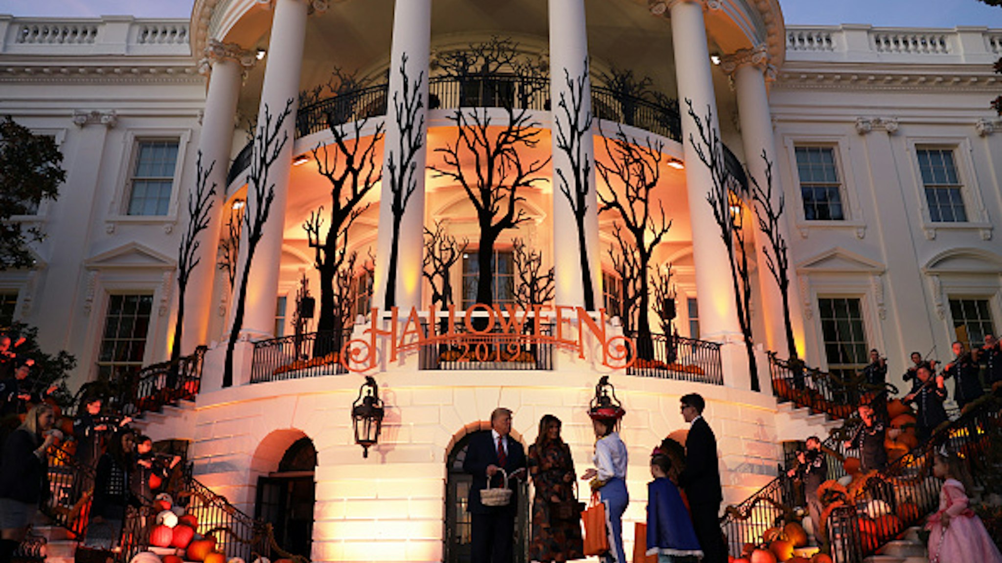 WASHINGTON, DC - OCTOBER 28: U.S. President Donald Trump and first lady Melania Trump hand out candy to trick-or-treaters during a Halloween at the White House event at the South Portico of the White House October 28, 2019 in Washington, DC.
