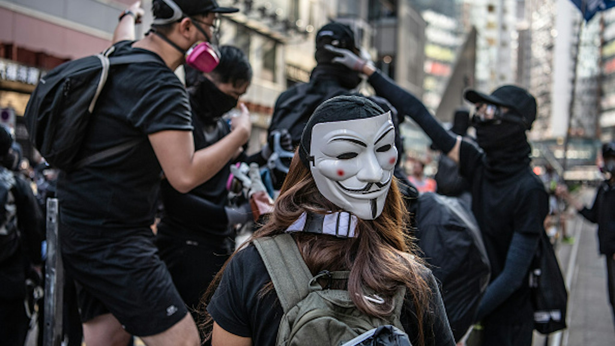 A demonstrator wears an anonymous masks, also known as Guy Fawkes masks, on the back of her head during a protest on Hennessy Road in the Causeway Bay district of Hong Kong, China, on Saturday, Nov. 2, 2019. Hong Kong police fired multiple rounds of tear gas at protesters who rallied for a 22nd consecutive weekend despite authorities denying them a permit to gather.