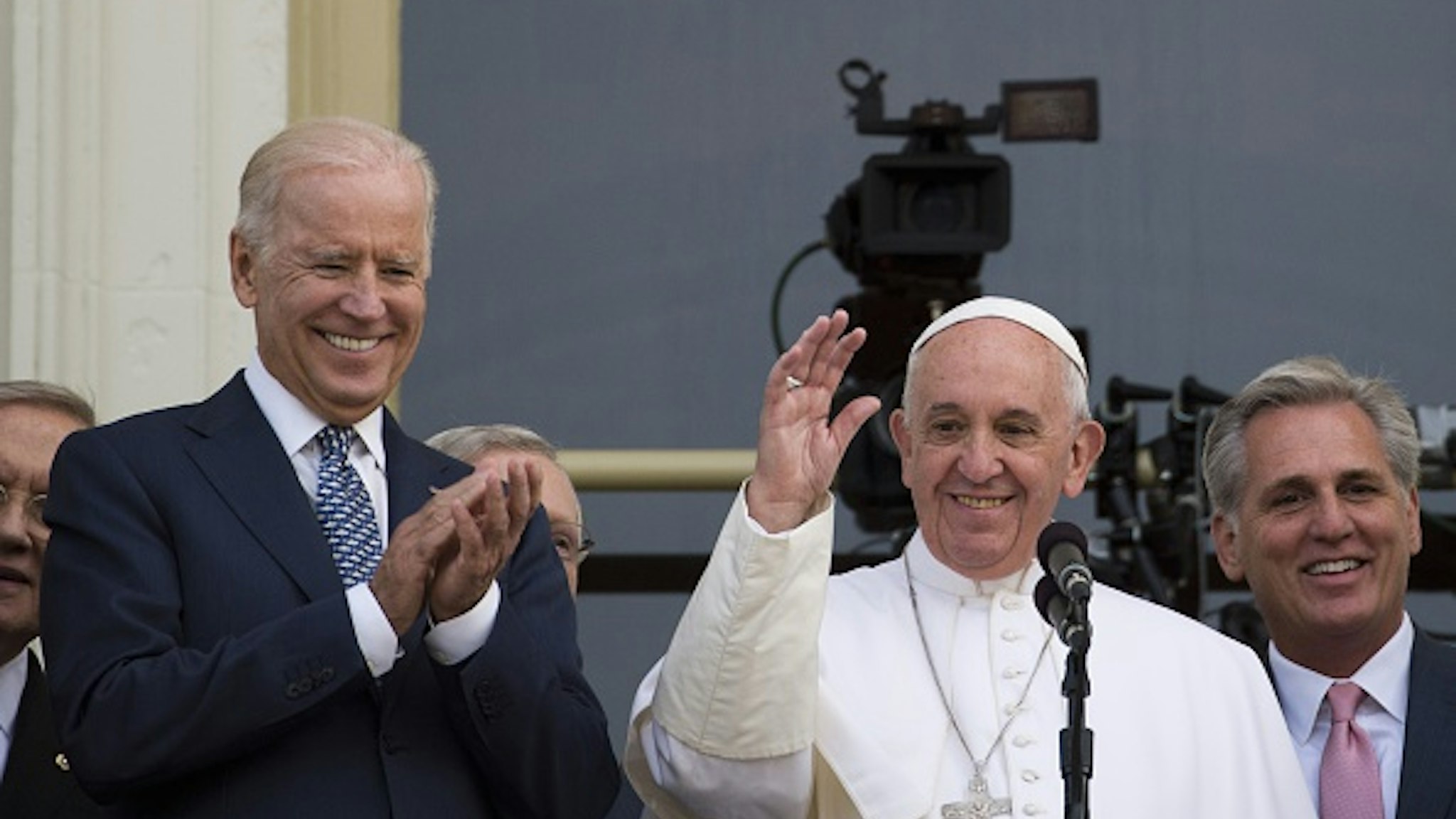 Pope Francis (C) waves, next to US Vice President Joe Biden(L), on a balcony after speaking at the US Capitol building in Washington, DC on September 24, 2015. AFP PHOTO/ ANDREW CABALLERO-REYNOLDS