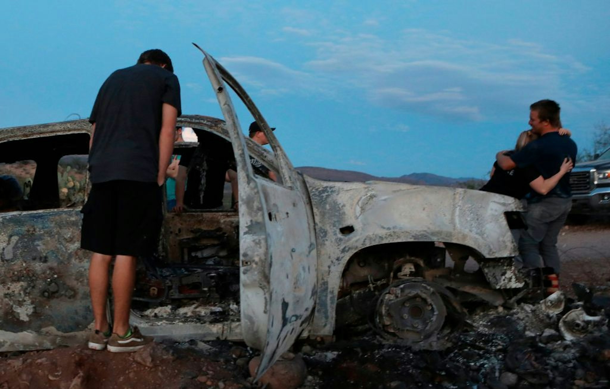 Members of the Lebaron family look at the burned car where part of the nine murdered members of the family were killed and burned during an ambush in Bavispe, Sonora mountains, Mexico, on November 5, 2019. - US President Donald Trump offered on November 5 to help Mexico "wage war" on its cartels after three women and six children from an American Mormon community were murdered in an area notorious for drug traffickers. (Photo by HERIKA MARTINEZ / AFP) (Photo by HERIKA MARTINEZ/AFP via Getty Images)