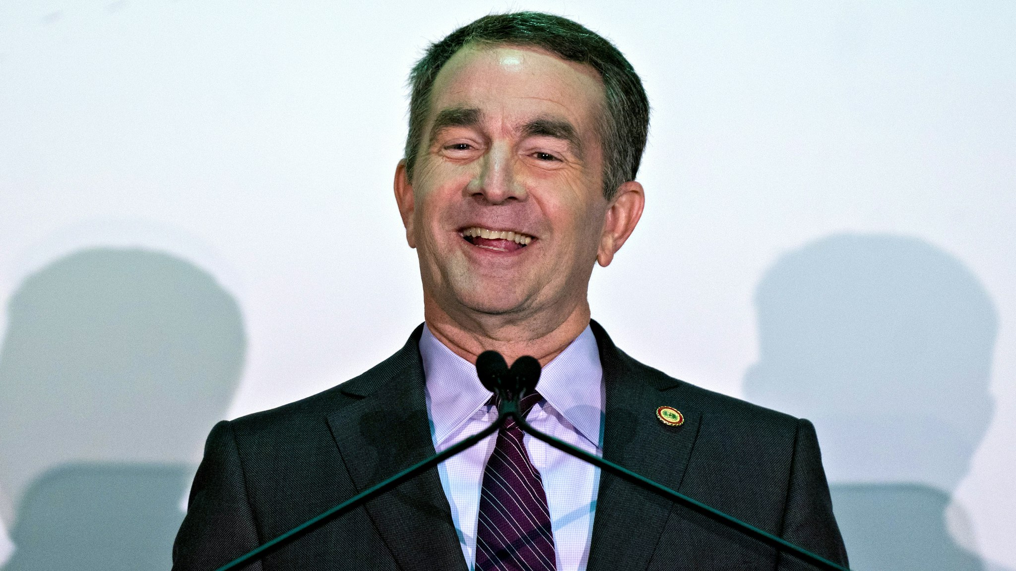 Ralph Northam, governor of Virginia, smiles while speaking during news conference in Arlington, Virginia, U.S., on Tuesday, Nov. 13, 2018. Amazon.com Inc. will build new offices in New York City and Arlington, ending months of jockeying between potential locations across the country vying for a $5 billion investment that promises 50,000 high-paying jobs over almost two decades.