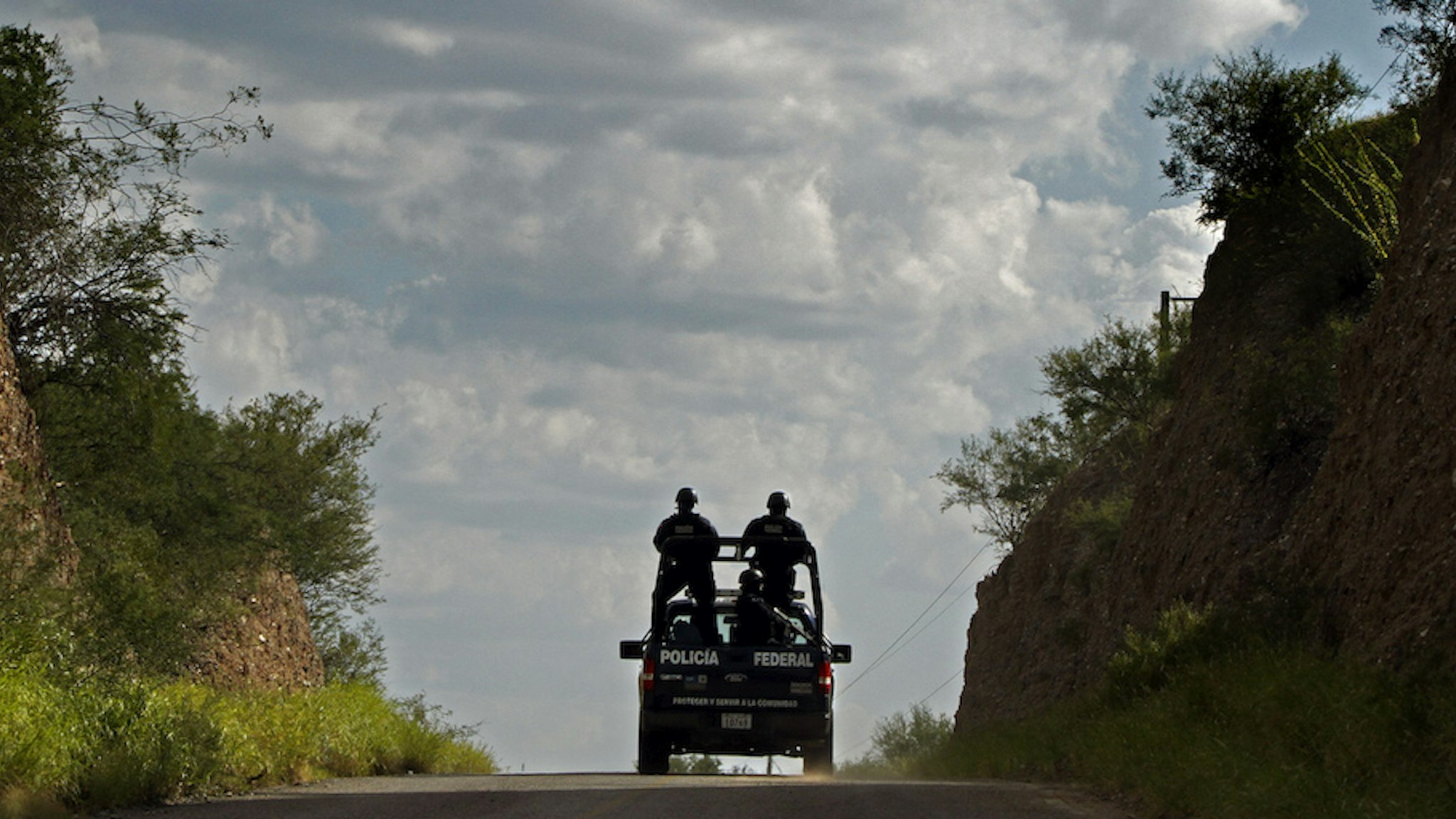 Mexican Federal Police drive through enemy territory south of the Arizona border. From the high embankments on this 2–lane desert road the Beltran–Leyva drug cartel gunmen ambushed and killed 21 Sinaloa Cartel gunmen in July, 2010. (Don Bartletti / Los Angeles Times)