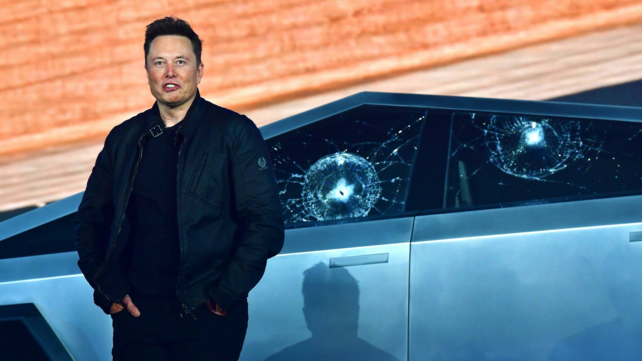 Tesla co-founder and CEO Elon Musk stands in front of the shattered windows of the newly unveiled all-electric battery-powered Tesla's Cybertruck at Tesla Design Center in Hawthorne, California on November 21, 2019.