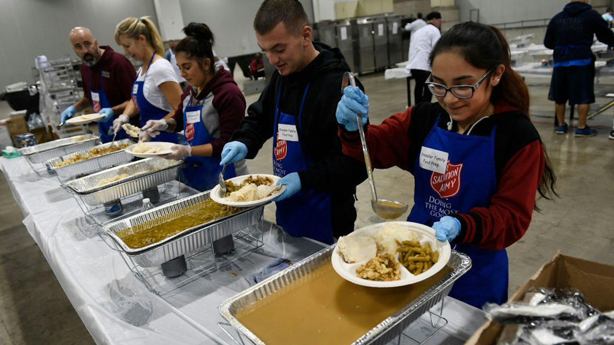 DENVER, CO - NOVEMBER 23 - Volunteers help serve food at the Thanksgiving day feast inside Exhibit Hall B at the Colorado Convention Center on November 23, 2017 in Denver, Colorado. The feast was sponsored by The Salvation Army as it continues its annual tradition of hosting Denvers Community Thanksgiving Meal. Over 150 volunteers helped to serve over 7,000 pounds of food to the homeless and needy. All of the food was donated by King Soopers and City Market. The warm traditional meal consisted of roasted turkey, mashed potatoes, string beans accompanied, rolls and delicious pies. The food was prepared by the Denver Sheriff's department, Denver Broncos' Athletes and the Salvation Army staff and volunteers.