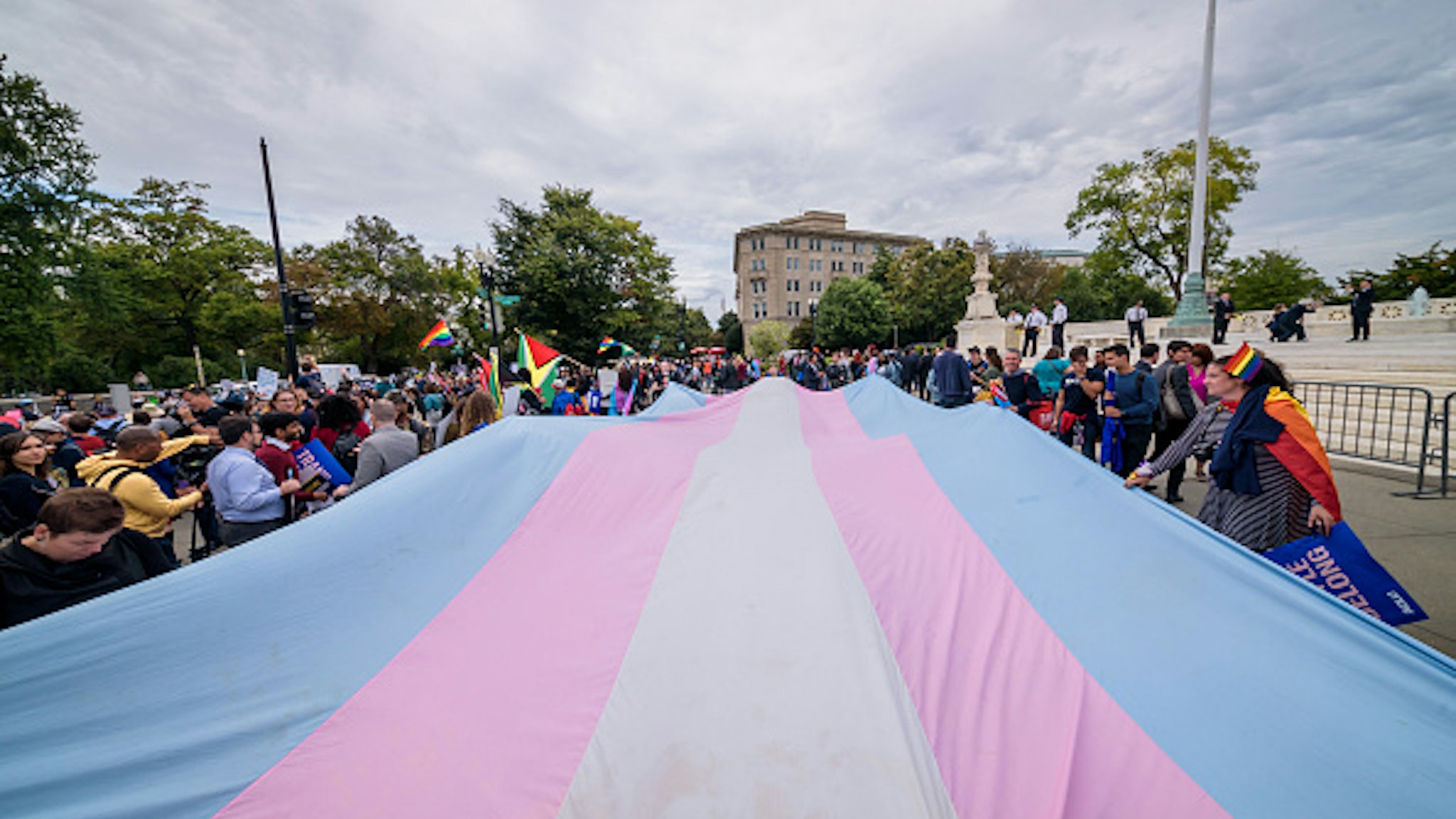 WASHINGTON DC, UNITED STATES - 2019/10/08: A giant Trans Flag unfurled outside the Supreme Court. 133 protesters were arrested blocking the street across the Supreme Court in an act of non violent civil disobedience, as hundreds of LGBTQ+ advocates convened in Washington, DC for a national day of action as a community response to the landmark Supreme Court hearings that could legalize workplace discrimination, primarily against LGBTQ+ people, on the basis of sexual orientation, gender identity, and gender presentation.