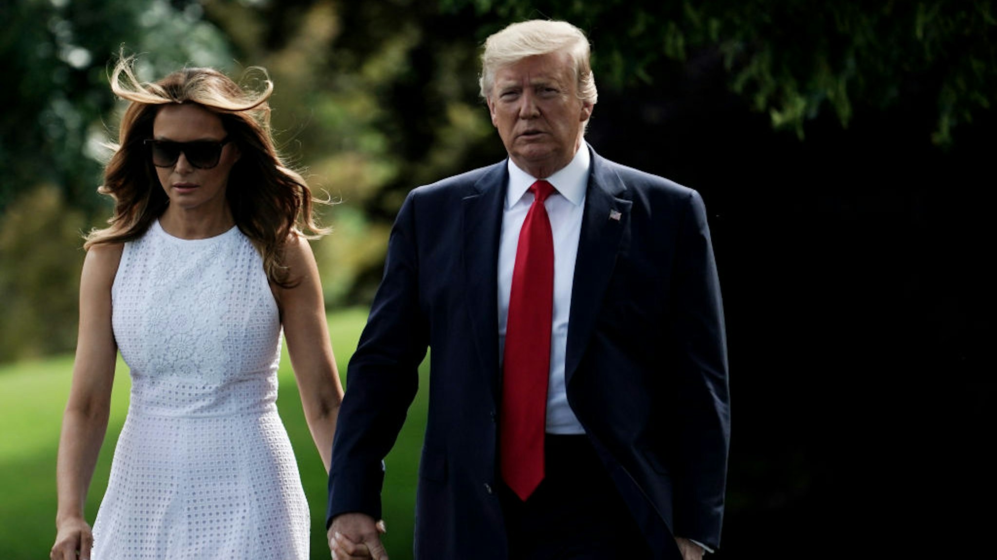 President Donald Trump walks with first lady Melania Trump prior to a departure from the White House