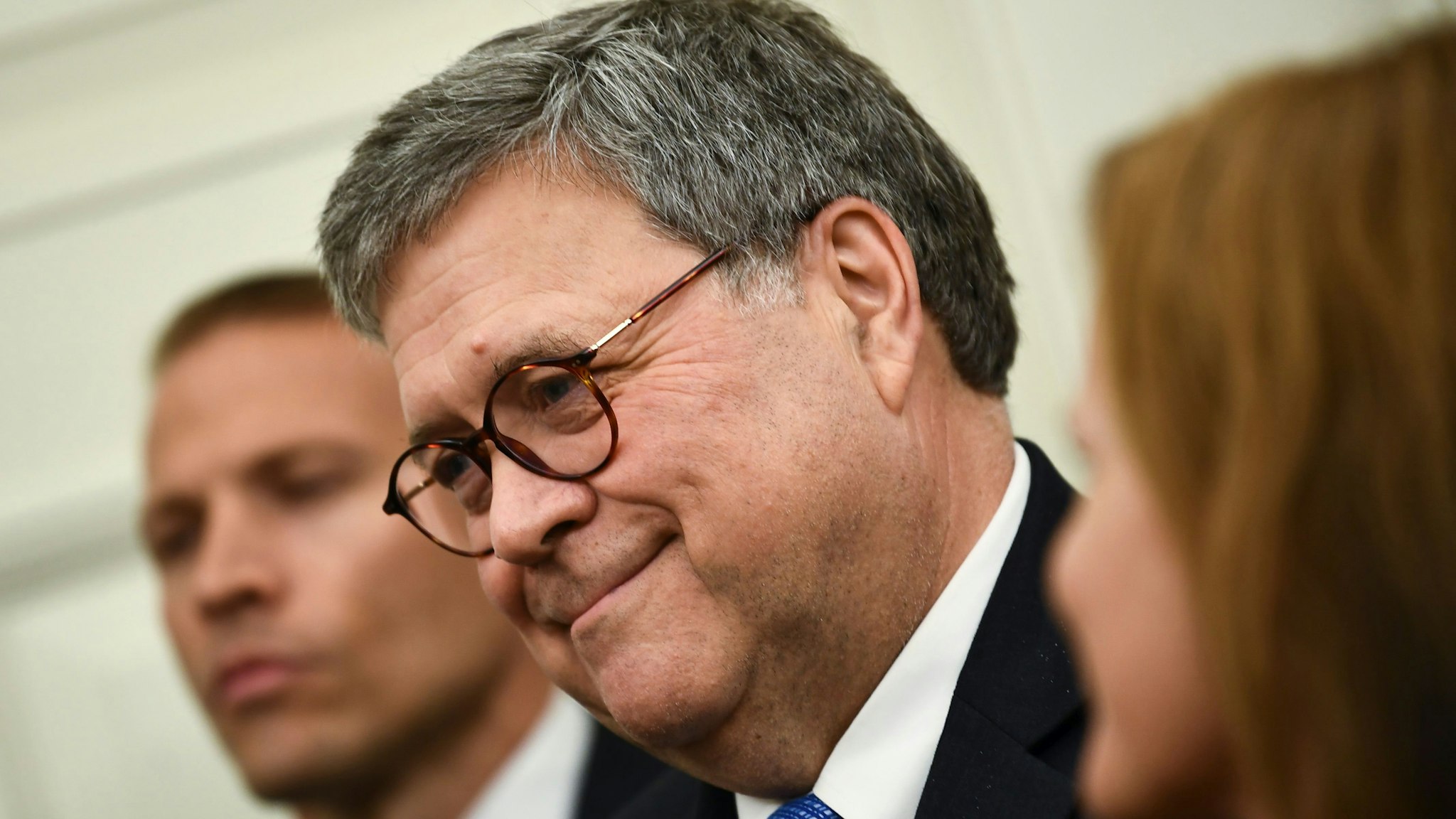 US Attorney General William Barr (C) looks on during a Medal of Freedom ceremony in the Oval Office at the White House in Washington, DC on October 8, 2019.