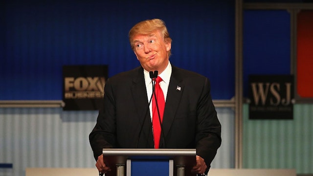 Presidential candidate Donald Trump gestures after Carly Fiorina says she met with Russian President Putin at a one on one meeting, during the Republican Presidential Debate sponsored by Fox Business and the Wall Street Journal at the Milwaukee Theatre November 10, 2015 in Milwaukee, Wisconsin.
