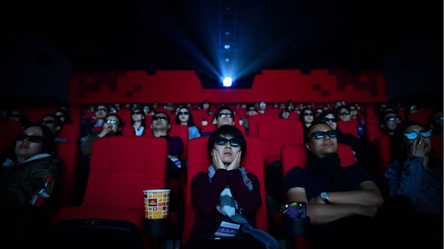 This picture taken on April 27, 2018 shows people watching a movie at a cinema in Wanda Group's Oriental Movie Metropolis in Qingdao, China's Shandong province.