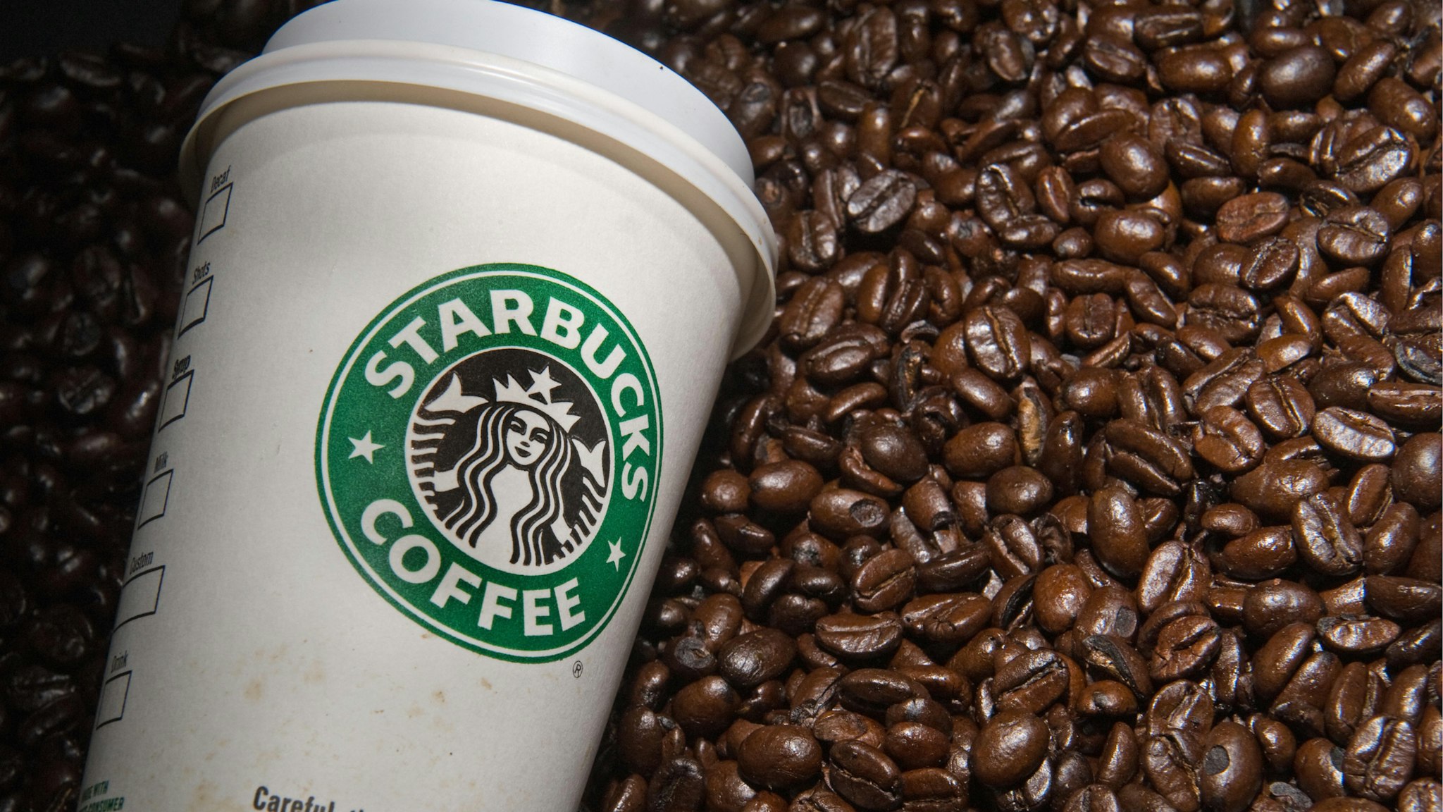 A Starbucks coffee cup and beans are seen in this photo taken August 12, 2009 in Washington, DC.