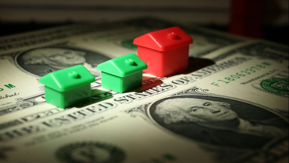 Cash houses. In this photo illustration miniature houses from a Monopoly board game can be seen next to American Dollar notes on October 23, 2008 in Manchester, England.