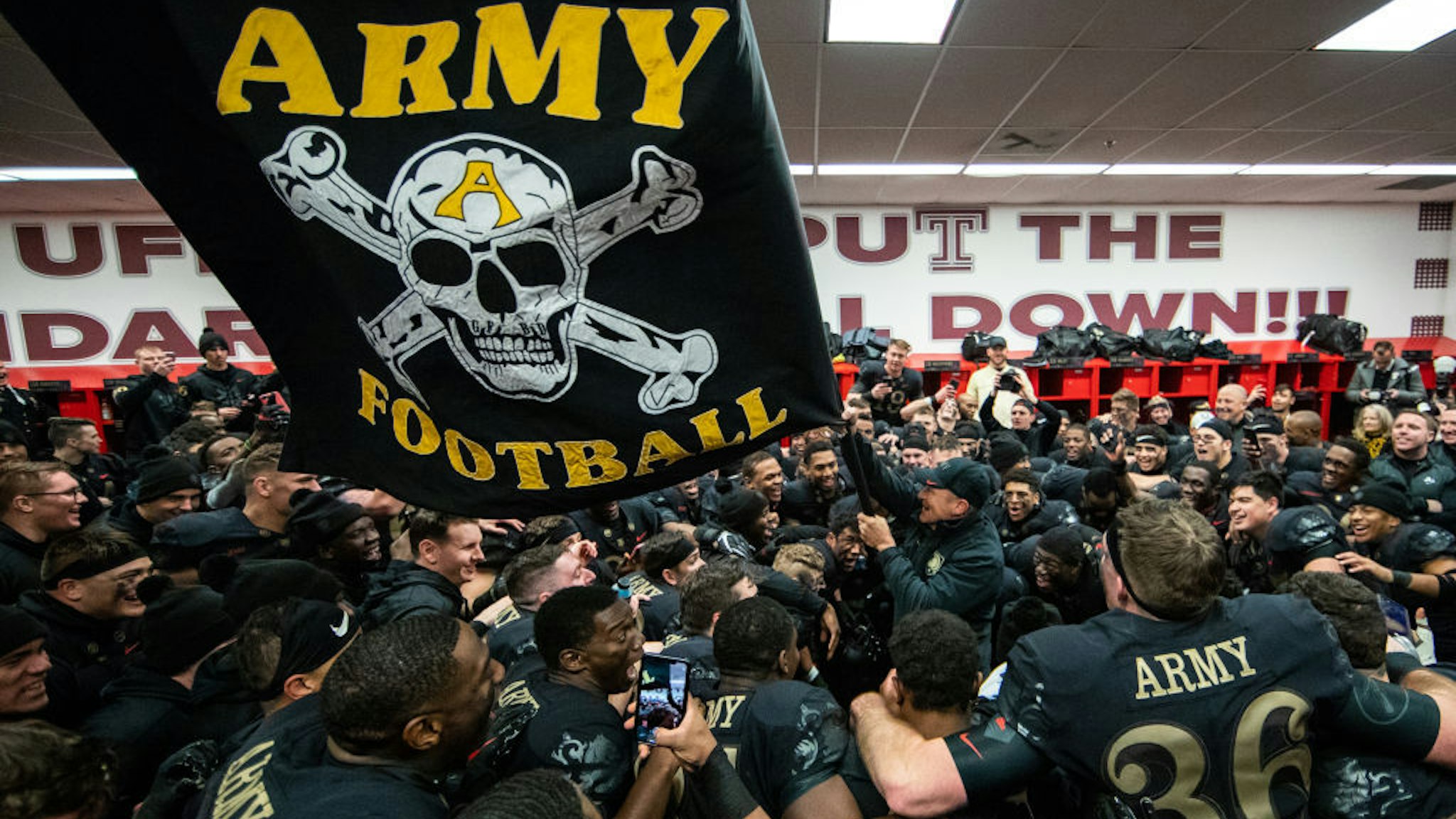 Jeff Monken, Head Coach of the Army Black Knights waves a flag in the locker room after defeating the Navy Midshipmen at Lincoln Financial Field on December 8, 2018 in Philadelphia, Pennsylvania. (Photo by Dustin Satloff/Getty Images)