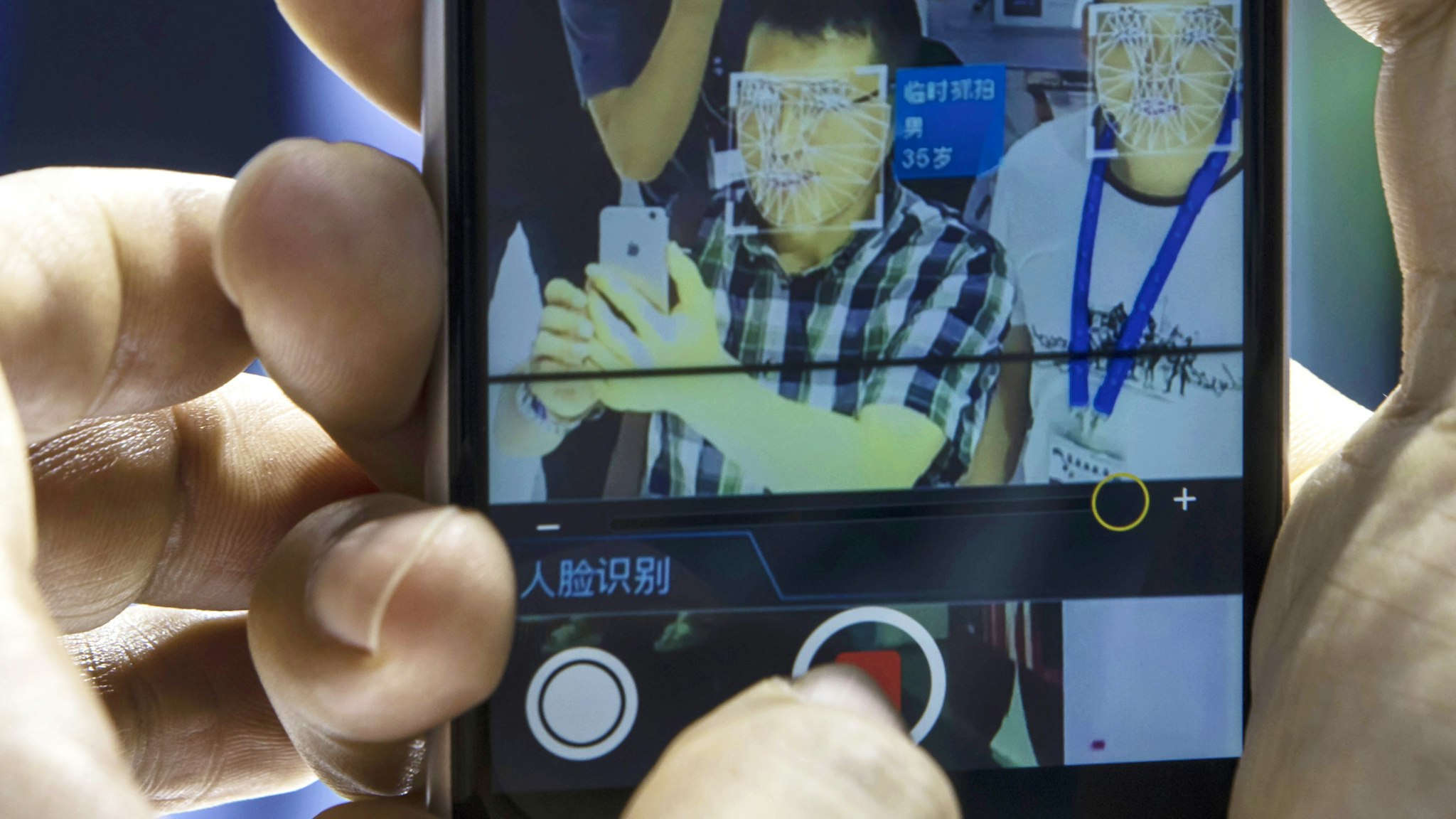 An attendee uses his smartphone to record a facial-recognition demonstration on himself at the Beijing Megvii Co. booth at the MWC Shanghai exhibition in Shanghai, China, on Thursday, June 27, 2019. The Shanghai event is modeled after a bigger annual industry show in Barcelona.