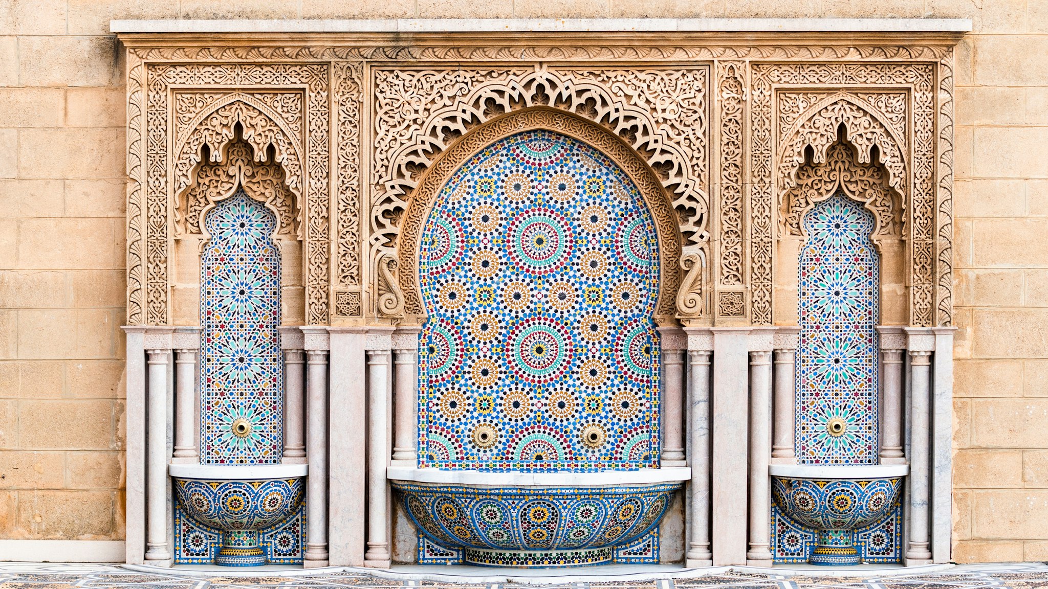 Water fountain with zelige intricate pattern of tiles in classic islamic style on the outside of Mosque Hassan in Rabat, Morocco