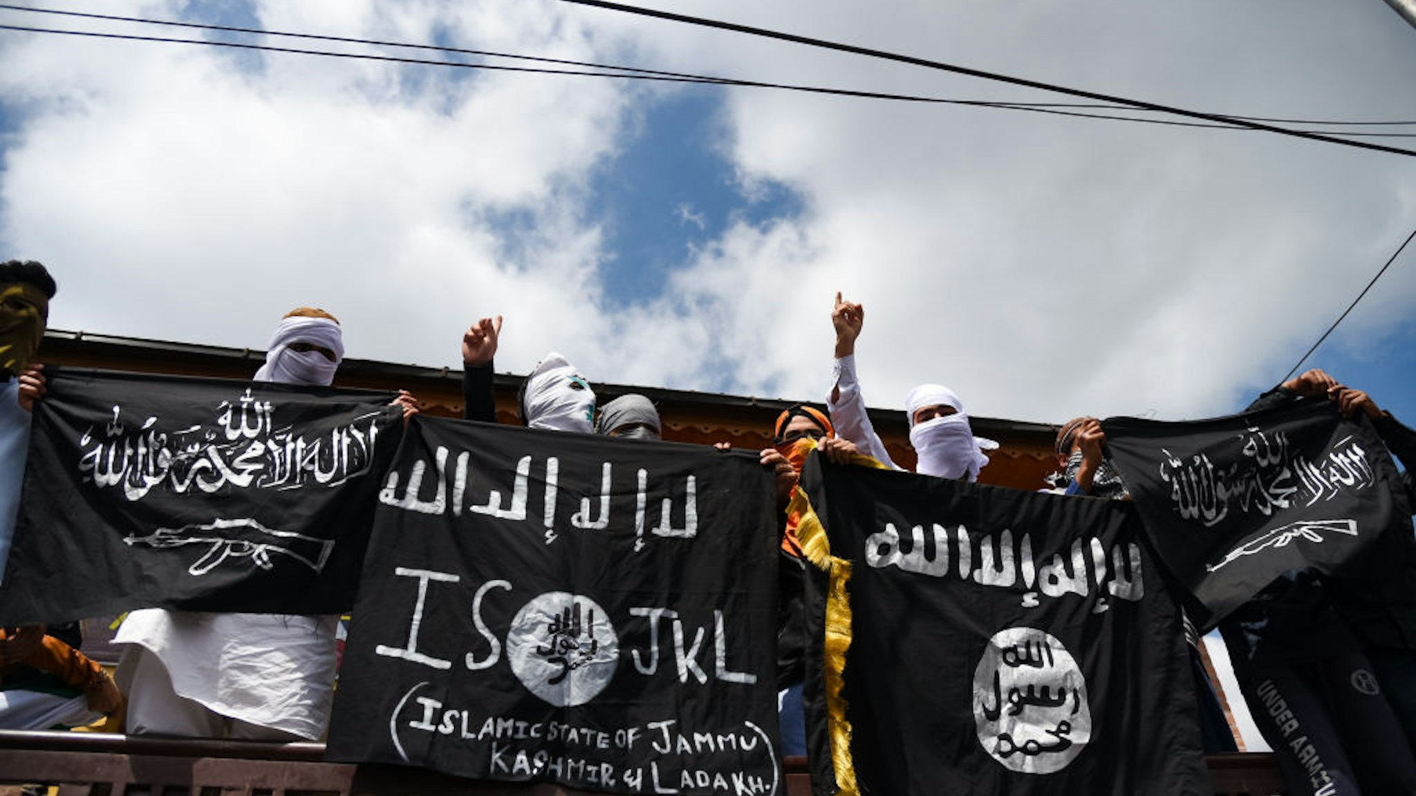 Kashmiri Protesters hold ISIS flags while making gestures during a protest in Srinagar. Indian forces in Srinagar used teargas smoke canisters and bullets to disperse hundreds of Protesters who took to streets after Eid-ul-Fitr prayers protesting against the Indian Rule in the region.