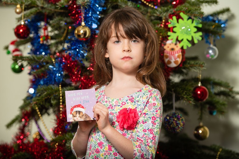 Florence Widdicombe, 6, at her home in Tooting, south London, holding a Tesco Christmas card from the same pack as a card she found contained a message from a Chinese prisoner.