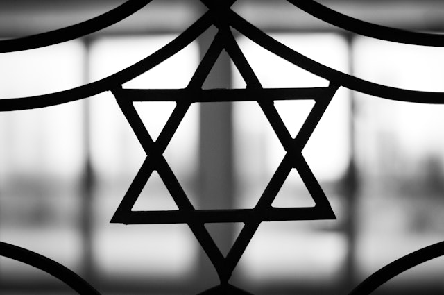 Iron casted Star in black and White with a dramatic back light overtone. The Star of David, known in Hebrew as the Shield of David or Magen David, is the quintessential symbol of Jewish identity.