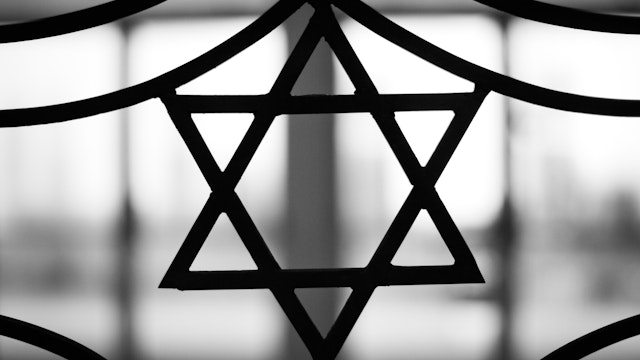 Iron casted Star in black and White with a dramatic back light overtone. The Star of David, known in Hebrew as the Shield of David or Magen David, is the quintessential symbol of Jewish identity.