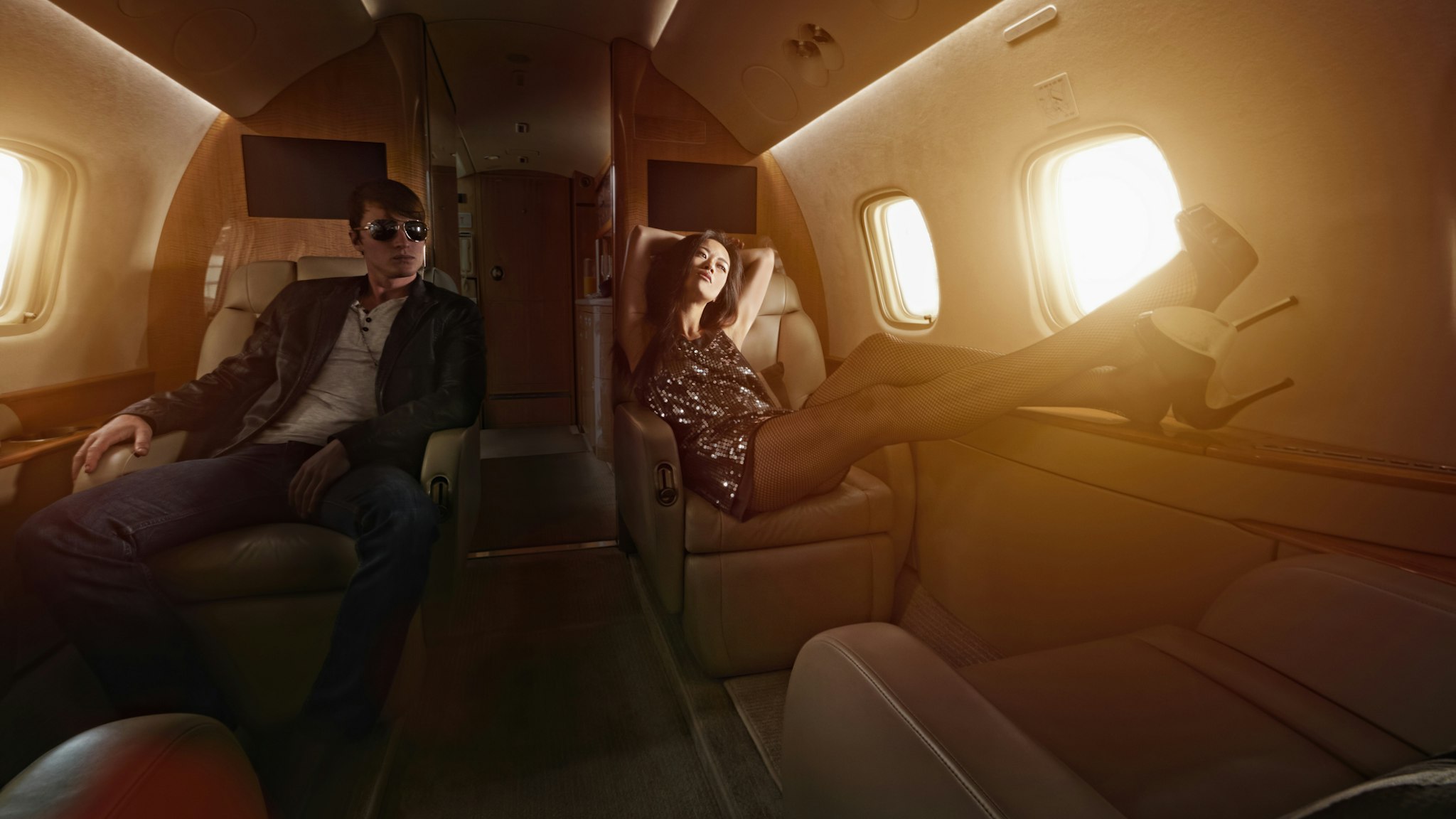Young couple flying on private jet - stock photo