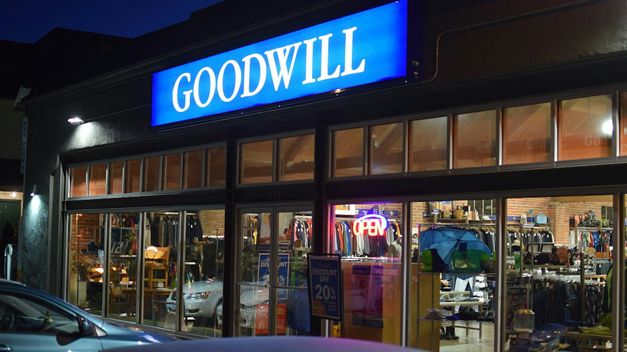 A Goodwill retail store front in the Capitol Hill neighborhood of Seattle, Washington. Cars are parked outside and thrift goods are seen through the windows of this urban location.