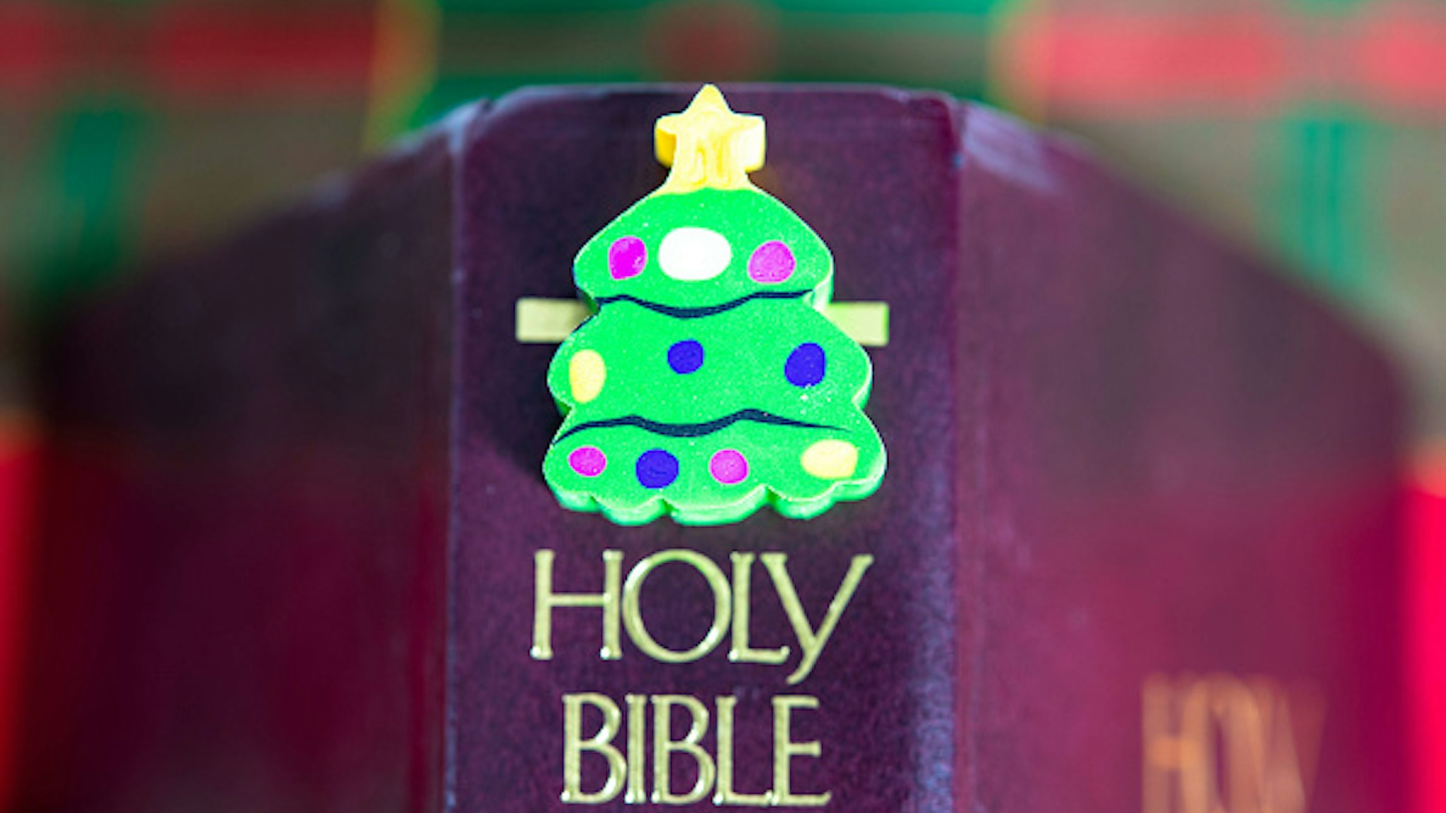 TORONTO, ONTARIO, CANADA - 2018/12/02: A small Christmas tree object over the Holy Bible. Christian origins of the Christmas holiday.