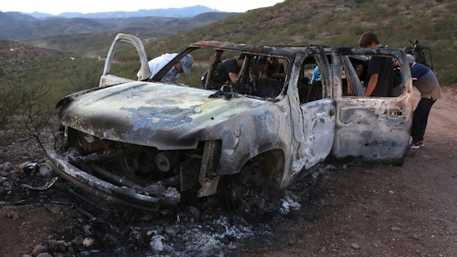 Members of the Lebaron family watch the burned car where part of the nine murdered members of the family were killed and burned during an gunmen ambush on Bavispe, Sonora mountains, Mexico, on November 5, 2019. - US President Donald Trump offered Tuesday to help Mexico "wage war" on its cartels after three women and six children from an American Mormon community were murdered in an area notorious for drug traffickers.