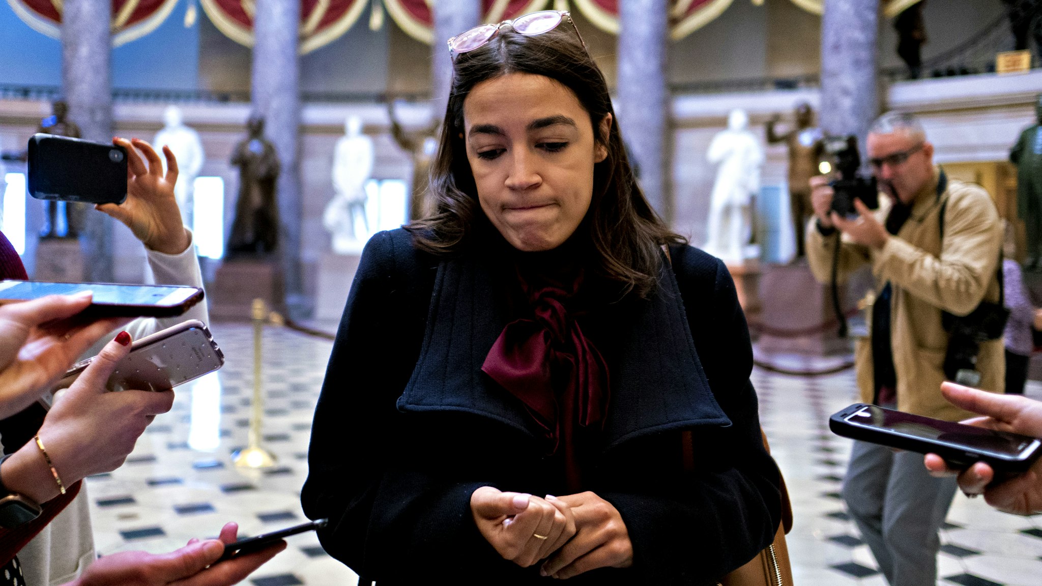 Representative Alexandria Ocasio-Cortez, a Democrat from New York, pauses while speaking to members of the media in Statuary Hall of the U.S. Capitol in Washington, D.C., U.S., on Wednesday, Dec. 18, 2019. The full House is set to debate and vote Wednesday on two impeachment articles accusing President Donald Trump of abusing his power and obstructing Congress's investigation of his actions toward Ukraine.