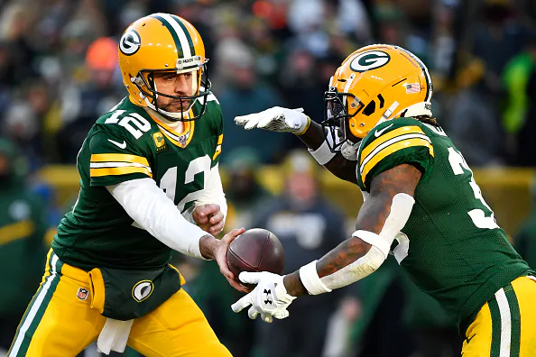 GREEN BAY, WISCONSIN - DECEMBER 15: Aaron Rodgers #12 of the Green Bay Packers hands the football off during the game against the Chicago Bears at Lambeau Field on December 15, 2019 in Green Bay, Wisconsin.