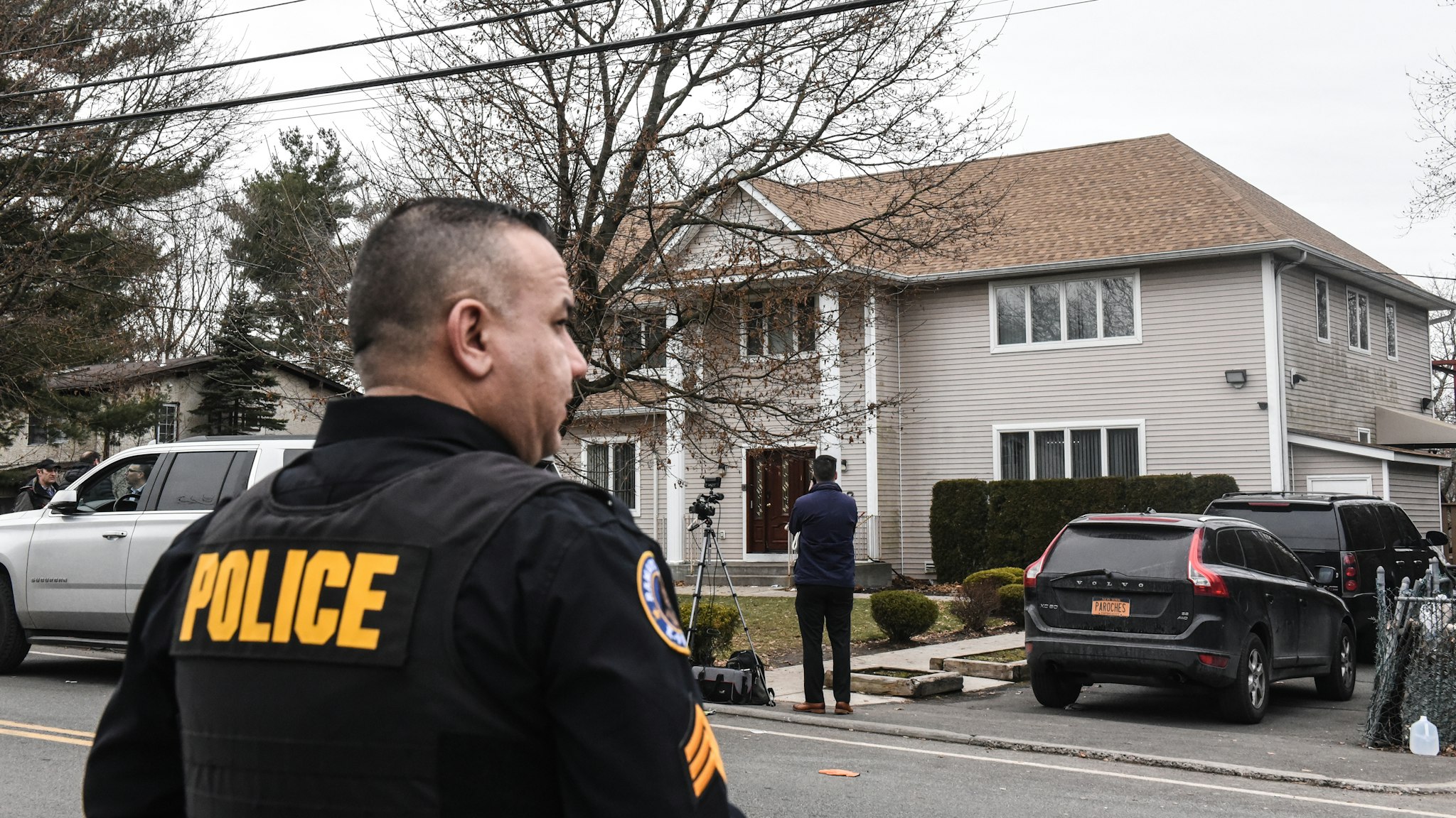 MONSEY, NY - DECEMBER 29: A member of the Ramapo police stands guard in front of the house of Rabbi Chaim Rottenberg on December 29, 2019 in Monsey, New York. Five people were injured in a knife attack during a Hanukkah party and a suspect, identified as Grafton E. Thomas, as was later arrested in Harlem.