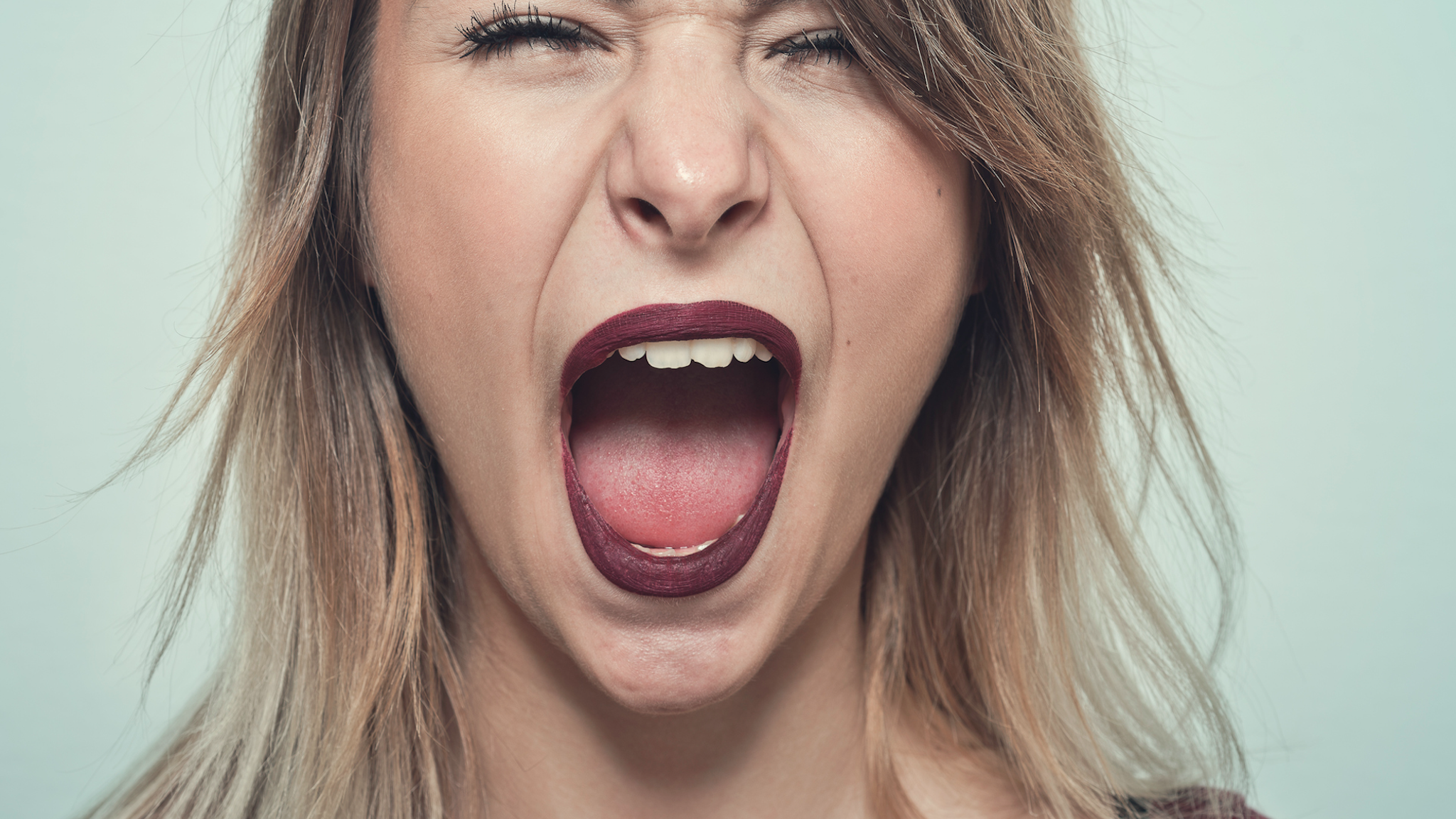 Close-uo of Young woman screaming.
