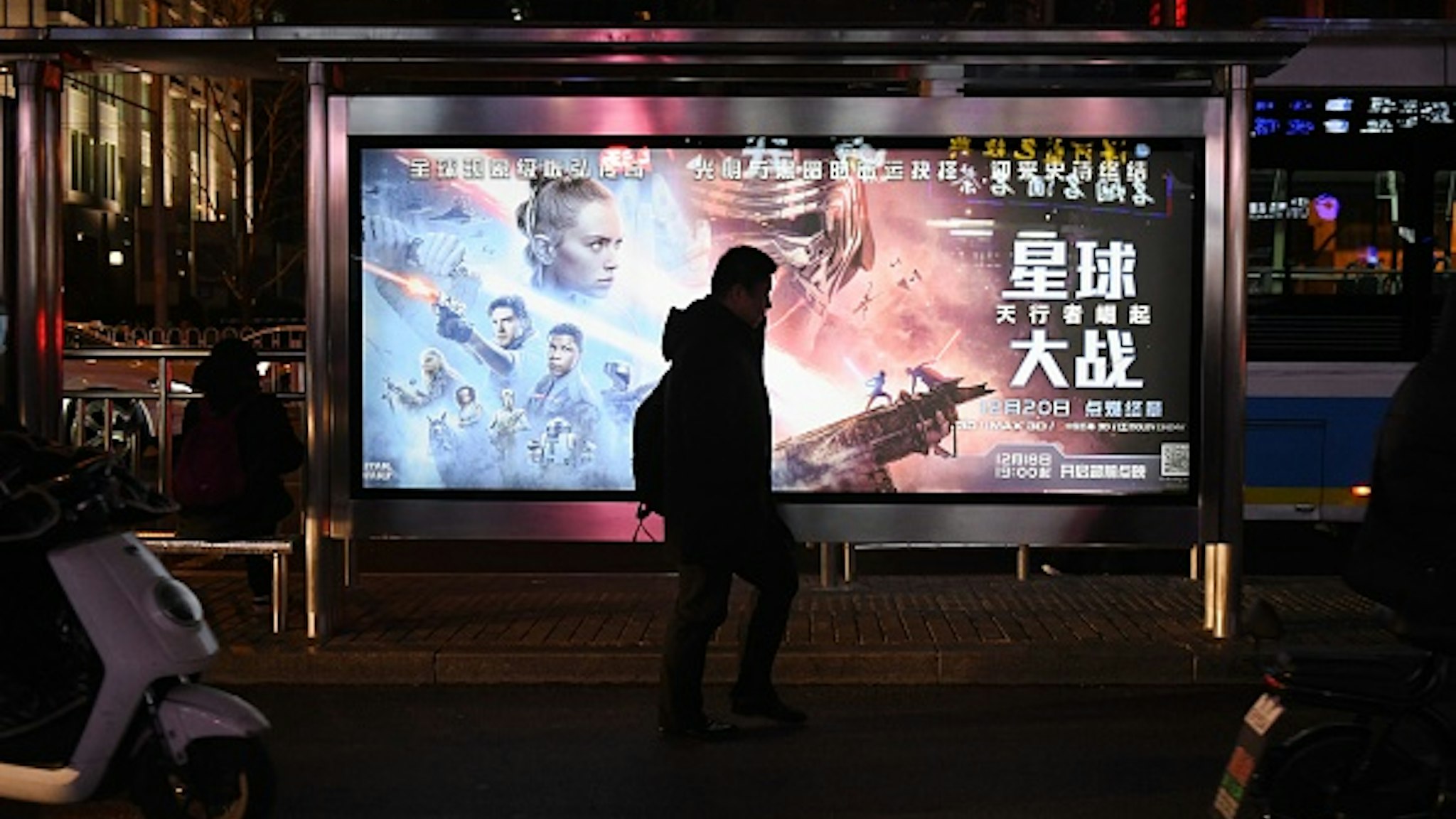 This photo taken on December 19, 2019 shows a man walking past a poster for the latest Star Wars movie, "The Rise of Skywalker", in Beijing. - The movie opens in theaters in China on December 20.